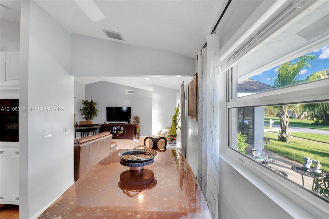 Vaulted ceilings, large picture window with natural light, and neutral wall color palette