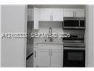 Kitchenette featuring white cabinetry, stainless steel appliances, a built-in microwave, and a gooseneck faucet