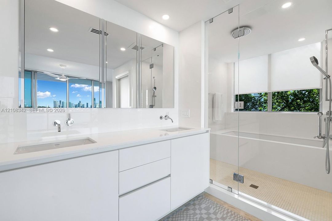 Floating dual-sink vanity with a solid surface countertop, large wall-to-wall mirror, glass-enclosed walk-in shower, built-in soaking tub, and recessed ceiling lighting