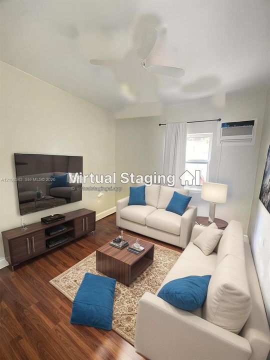 Wood-finish flooring, white ceiling fan, and wall-mounted air conditioning unit