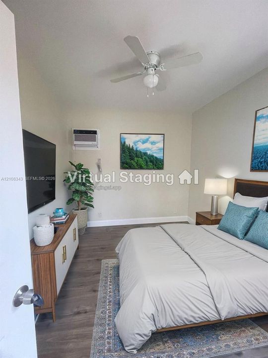Room featuring wood-finish flooring, a ceiling fan with integrated lighting, and a wall-mounted air conditioning unit