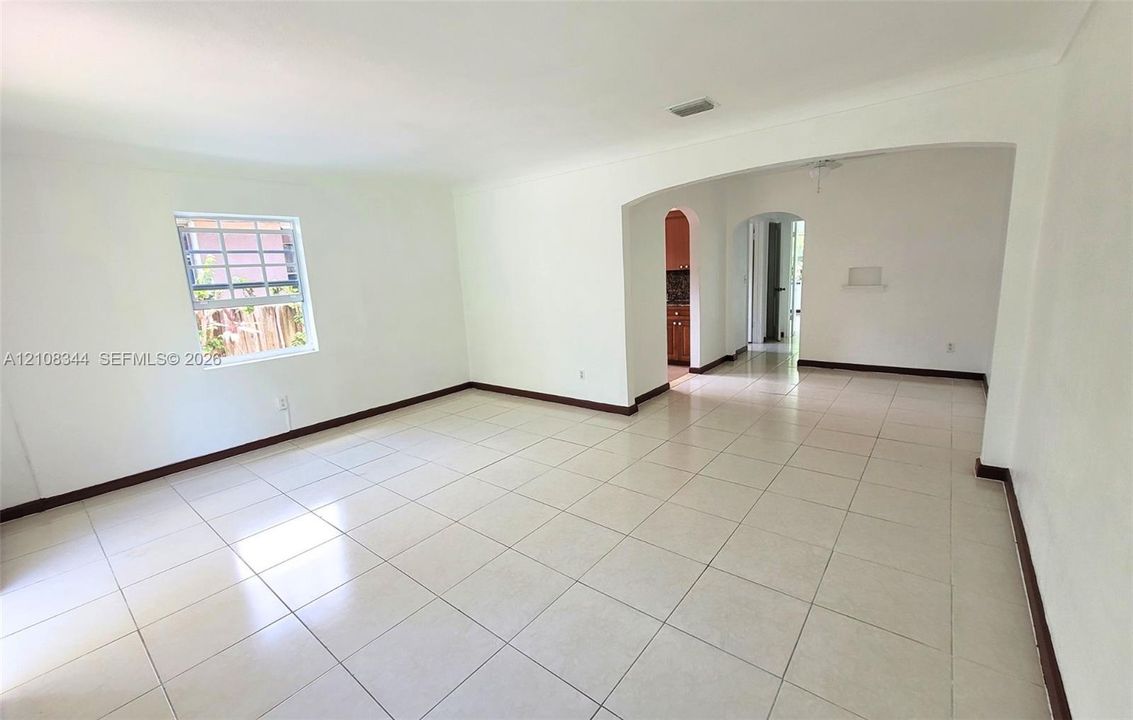 Bright, spacious living room with neutral tile flooring and plenty of natural light.