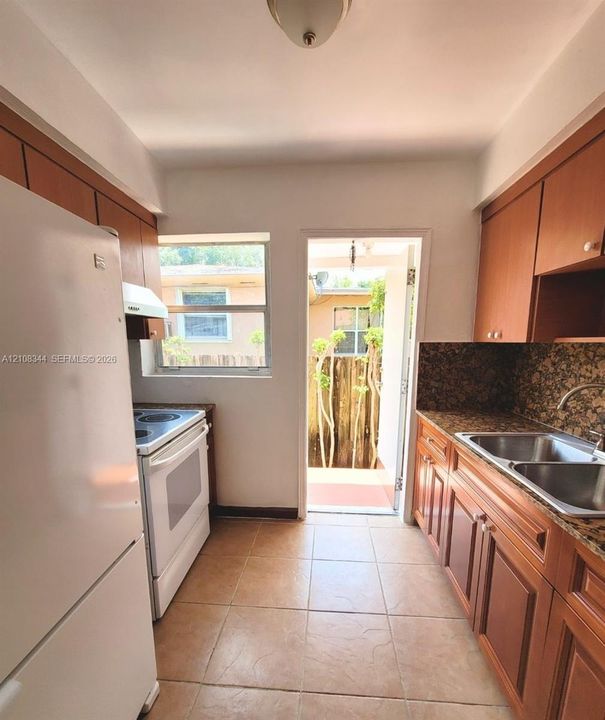 Another view of the kitchen featuring wood cabinetry and a practical layout.