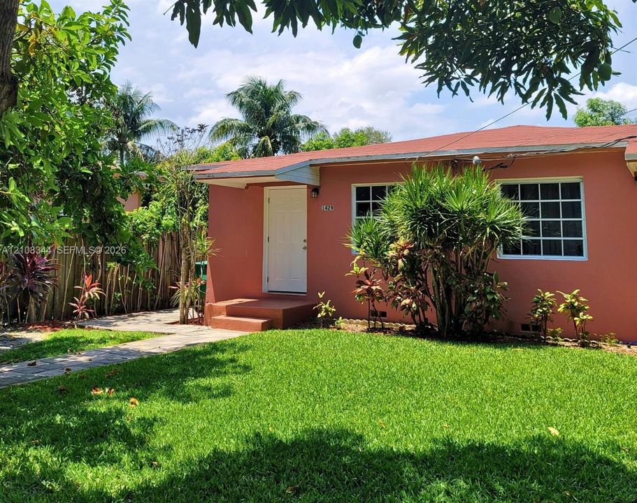 Charming duplex residence with a single-family-home feel, gated entrance, and spacious front yard.
