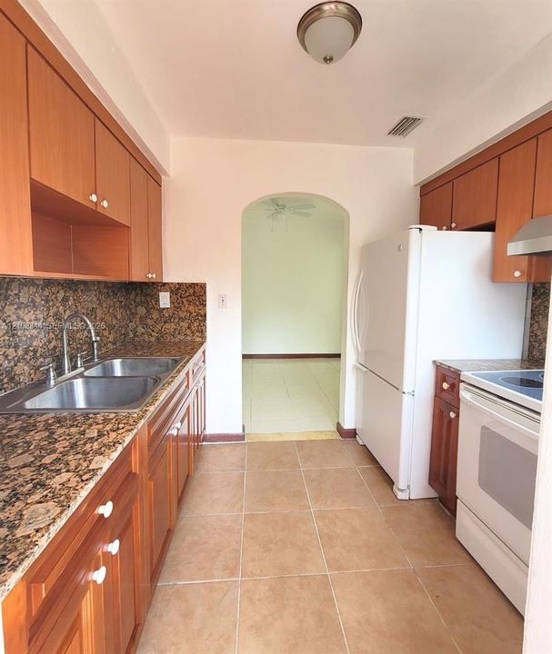 Functional kitchen with wood cabinetry, generous counter space, and natural light.