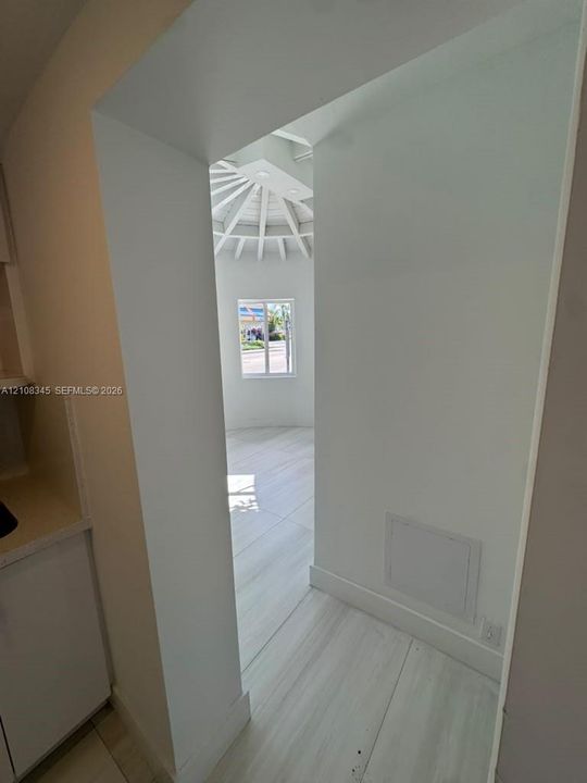 Vaulted radial ceiling with integrated lighting, wood-finish flooring, and crisp white architectural detailing