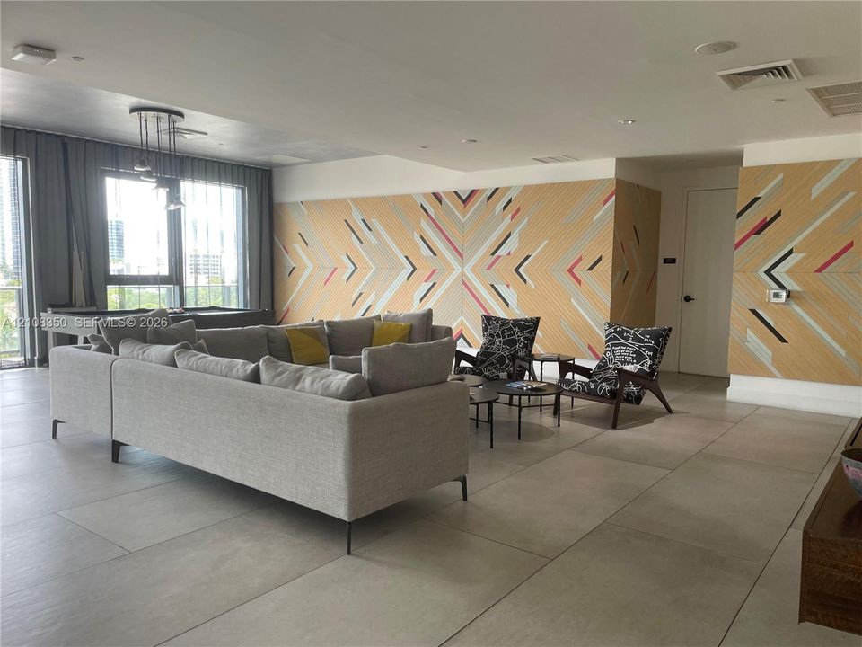 Large-format tile flooring, geometric wall paneling, and recessed ceiling lighting