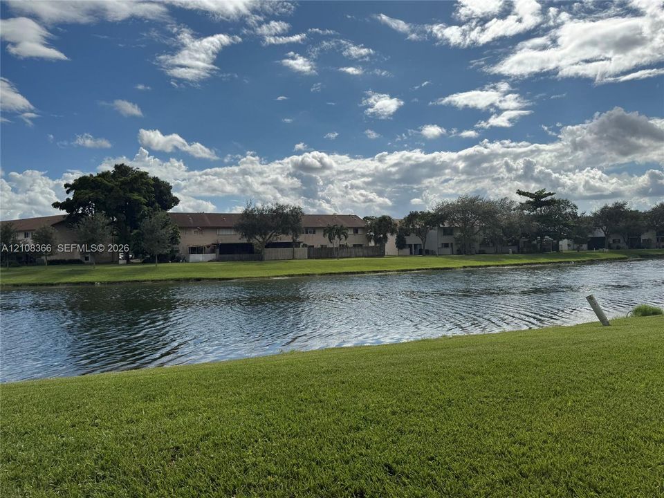 Waterfront property featuring a manicured lawn, expansive canal frontage, and mature trees