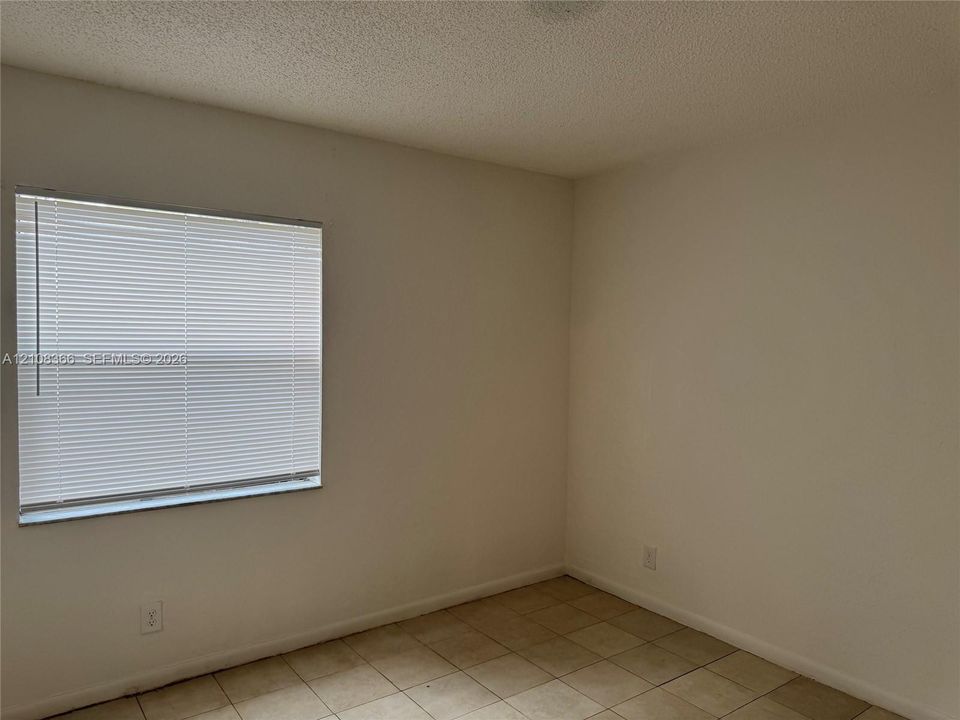 Neutral-toned wall finish, ceramic tile flooring, and horizontal window blinds