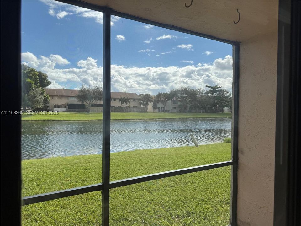 Screened-in enclosure featuring a water-facing orientation, exterior grass lawn, and metallic structural framing