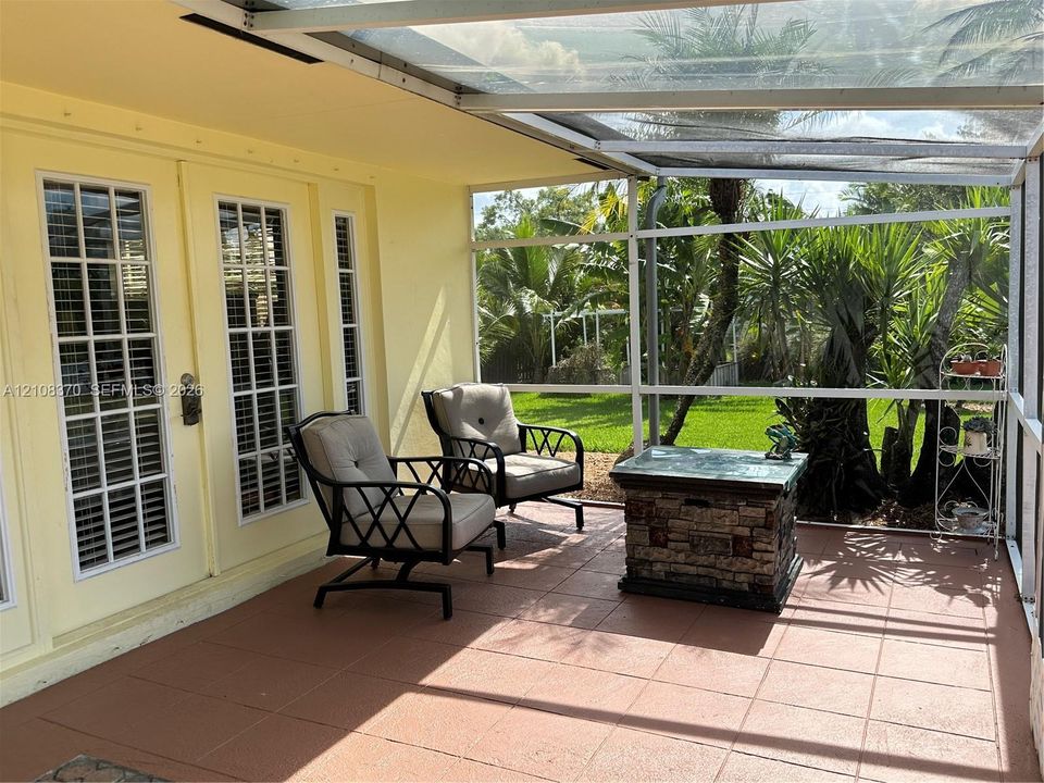 Screened-in porch featuring a tile floor, glass-paneled entry doors, and a transparent roof covering