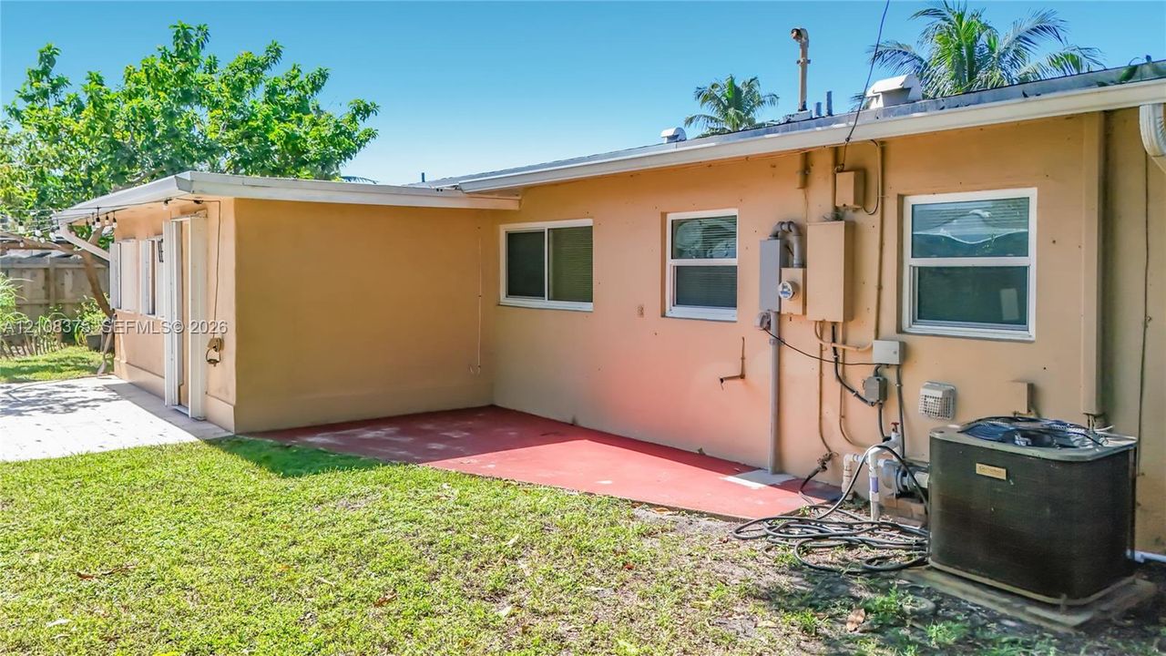 Exterior view featuring a concrete patio, horizontal sliding windows, and a dedicated central air conditioning unit