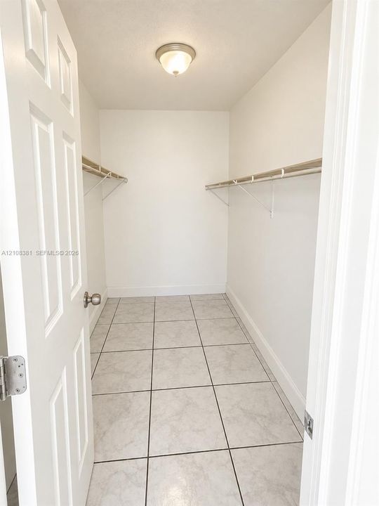 Walk-in closet featuring ceramic tile flooring, dual-level wire shelving, and a flush-mount ceiling light fixture