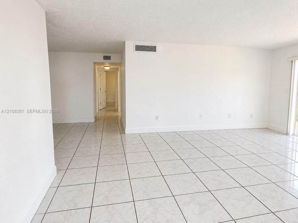 Neutral-toned ceramic tile flooring, smooth white wall finishes, and glass sliding door access to exterior space