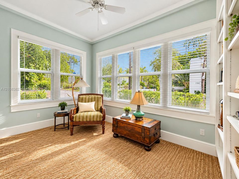 Multi-pane windows, built-in shelving, white ceiling fan, and extensive trim work