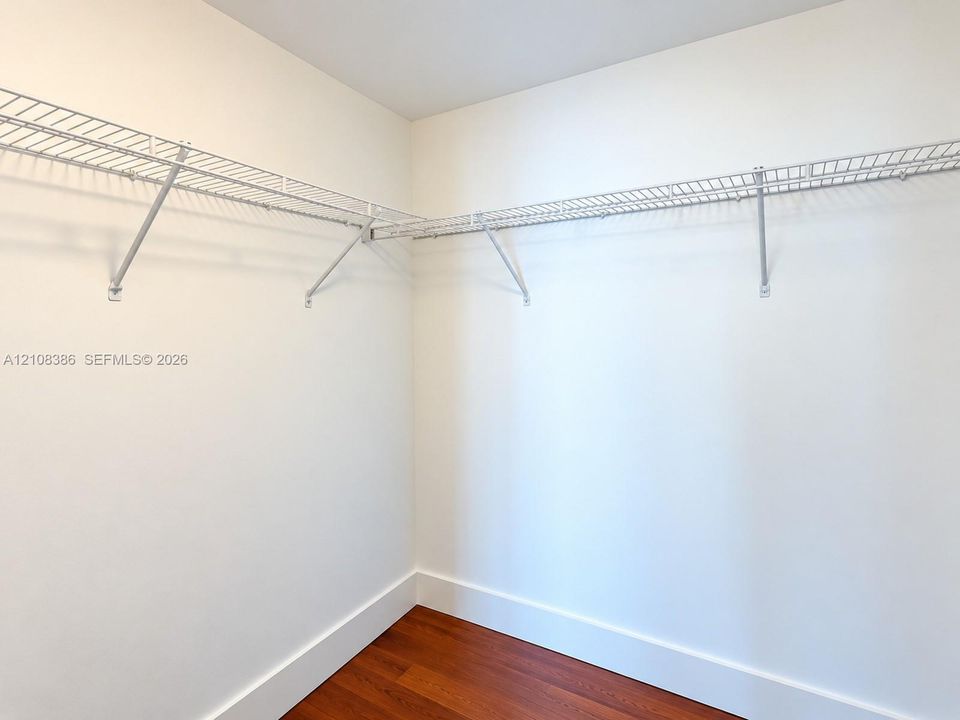 Walk-in closet featuring wood-finish flooring and white wire shelving