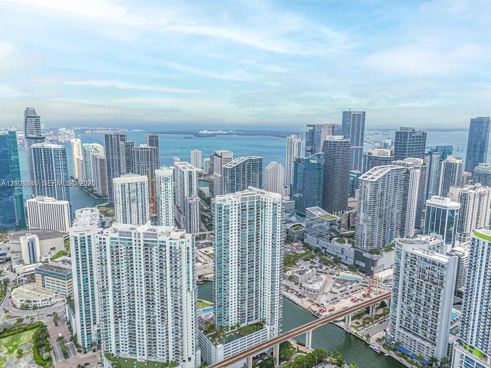 Aerial perspective featuring an extensive urban skyline, high-rise architectural density, and prominent coastal waterfront