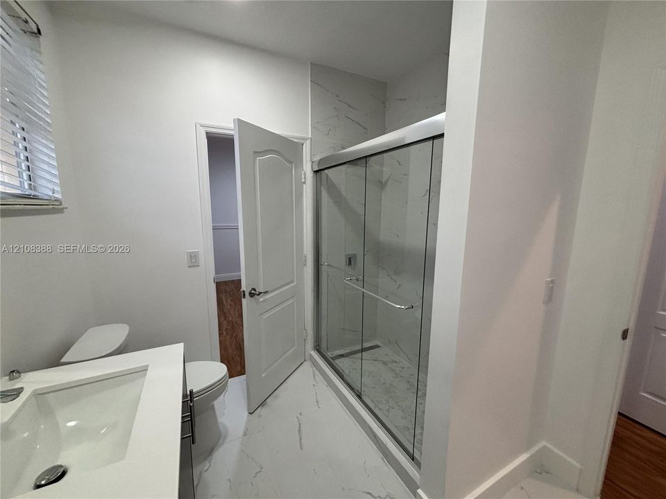 Utility room featuring neutral tile flooring, recessed ceiling lighting, a dedicated window, and a built-in wire storage shelf