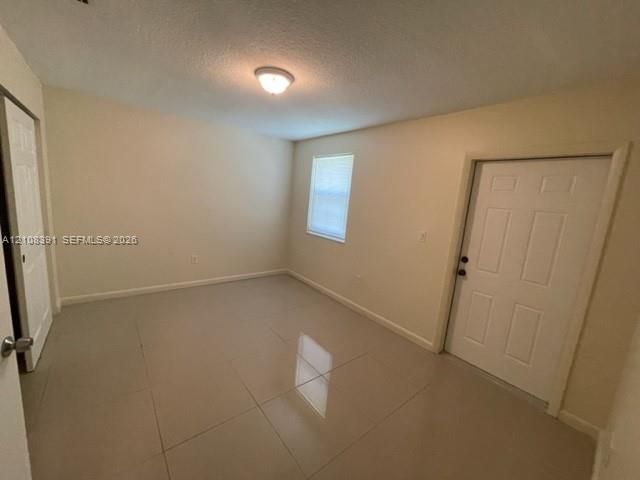 Large-format tile flooring, neutral wall tones, single-hung window, and six-panel interior and exterior doors