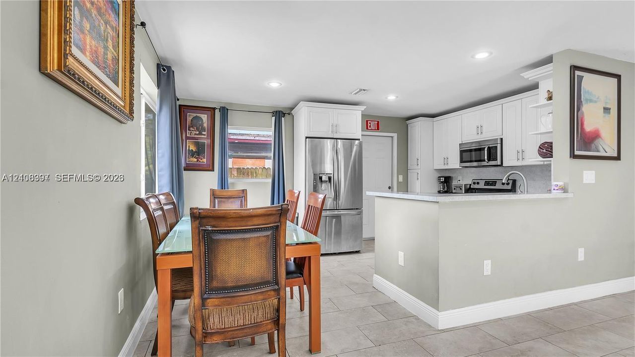 Kitchen featuring white cabinetry, stainless steel appliances, a peninsula counter, recessed lighting, and tile flooring