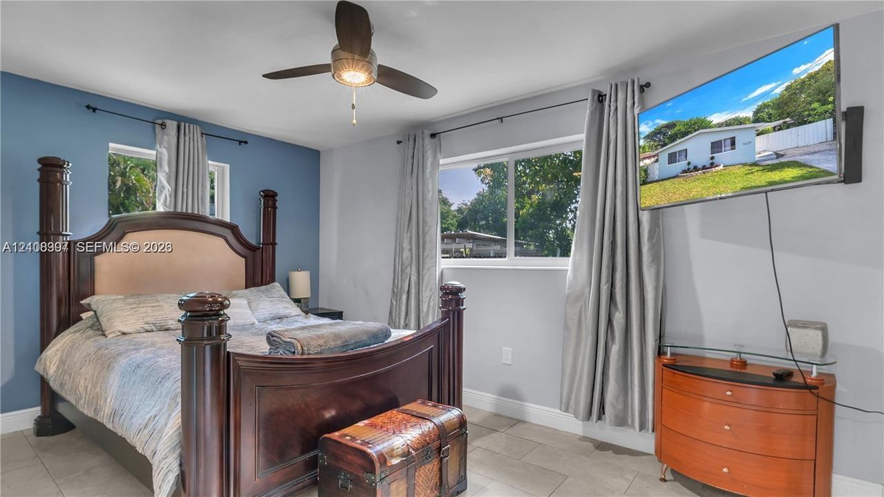 Neutral wall tones with a blue accent wall, tile flooring, and a ceiling-mounted light fixture with fan