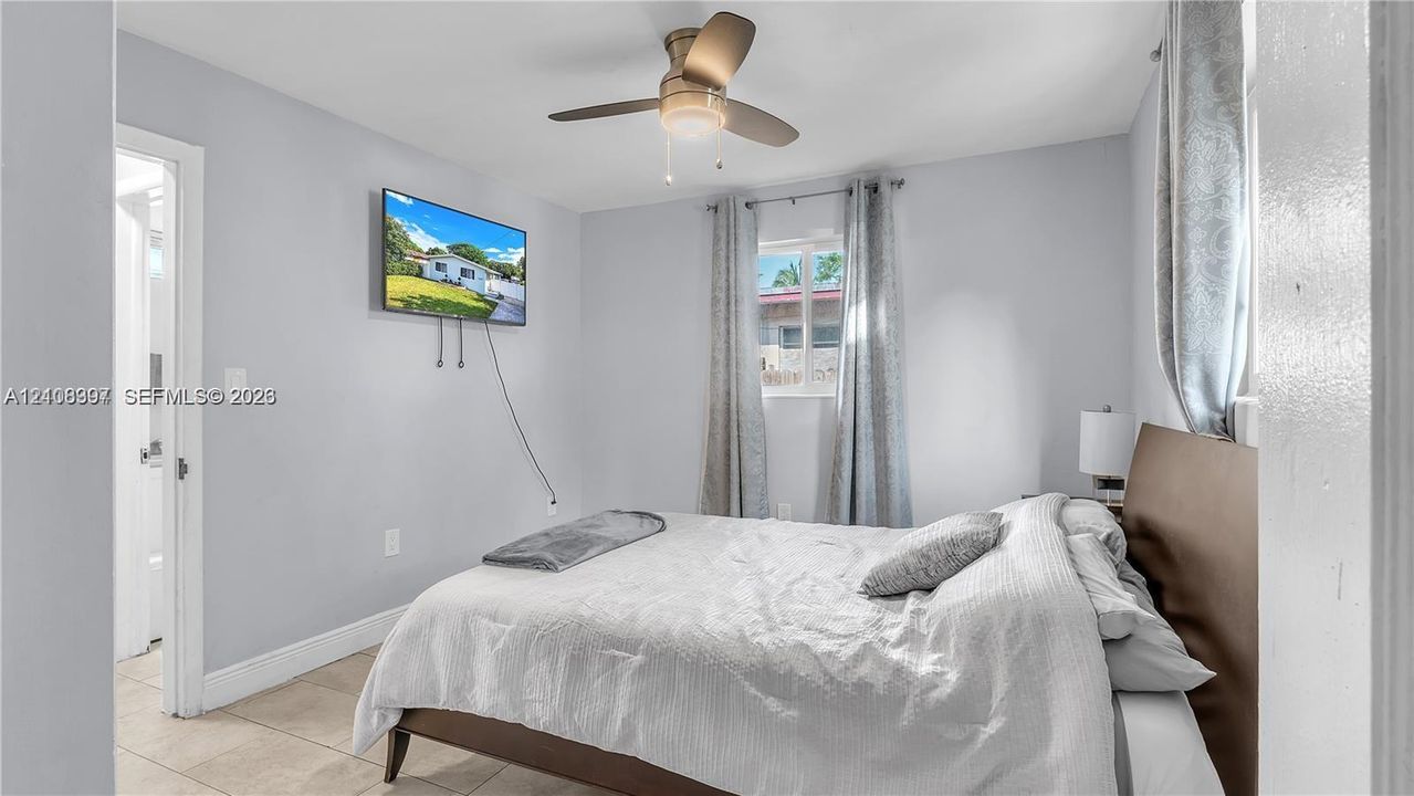 Neutral wall tones, tile flooring, and a ceiling fan with integrated lighting