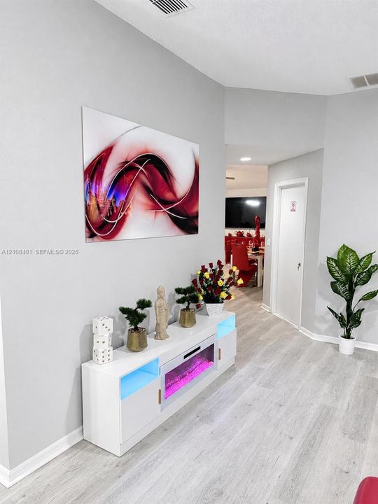 Neutral-toned interior featuring light-toned wood-finish flooring, recessed lighting, and crisp, minimalist wall finishes