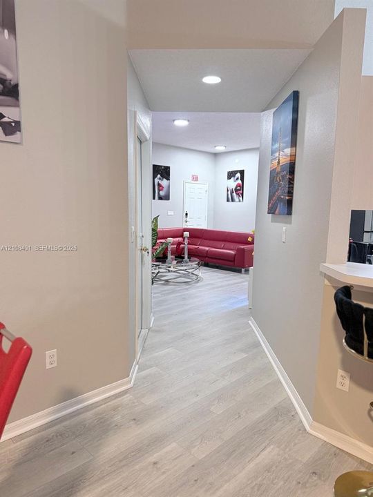 Light-toned wood-finish flooring, recessed lighting, and a neutral color palette