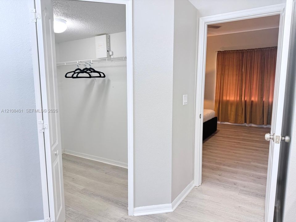 Walk-in closet featuring wire shelving, wood-finish flooring, and a ceiling-mounted light fixture