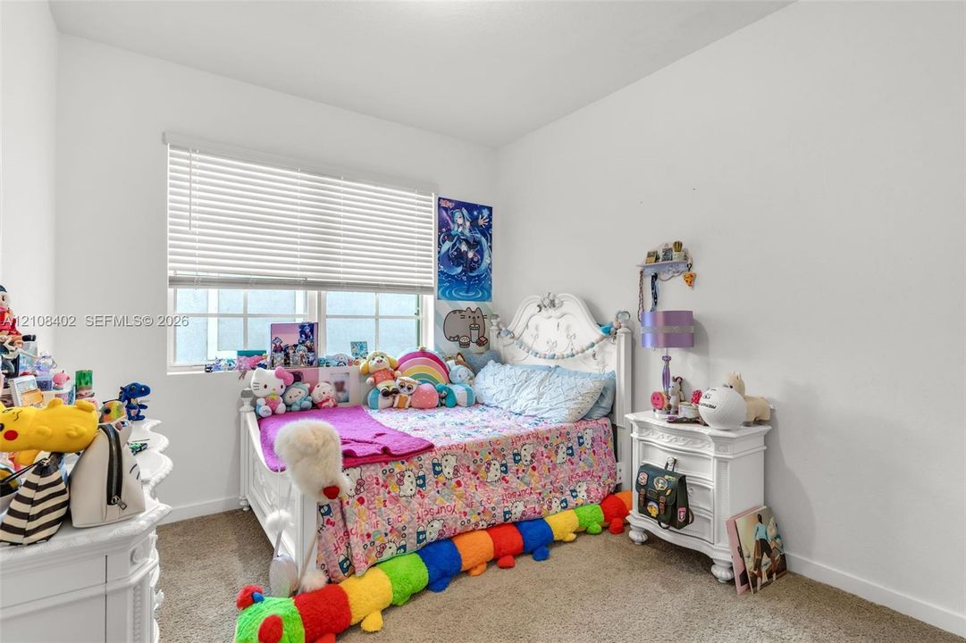 Neutral interior room featuring neutral-toned carpeting, white walls, and a multi-pane window with installed horizontal blinds