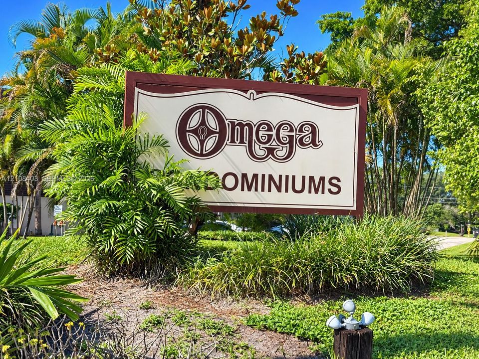 Custom architectural signage set within a manicured landscape featuring mature palm trees and established tropical greenery