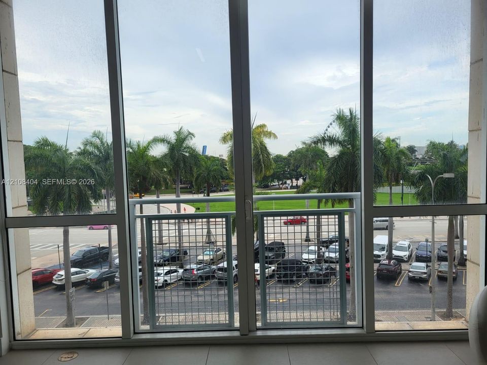 Floor-to-ceiling windows featuring a white metal grid balcony railing