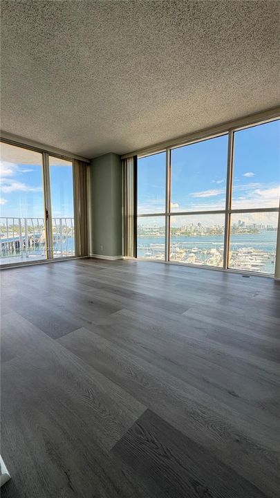 Interior space featuring floor-to-ceiling windows, water-front exposure, expansive glass sliders, and wood-finish flooring