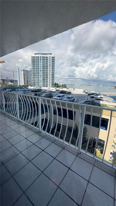 Covered balcony featuring white metal railings and tiled flooring