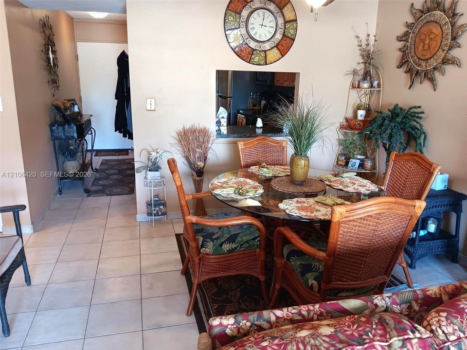 Ceramic tile flooring throughout and wall cutout featuring a stone-topped breakfast bar