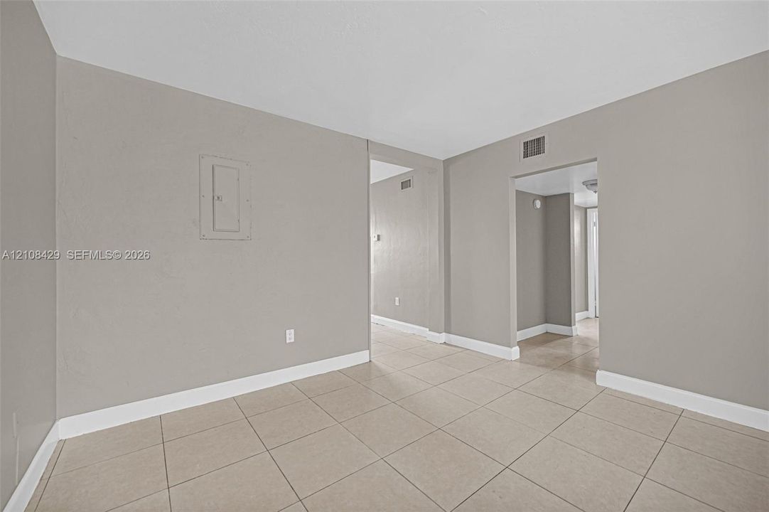 Interior space featuring neutral-toned walls, tile flooring, and recessed doorway openings