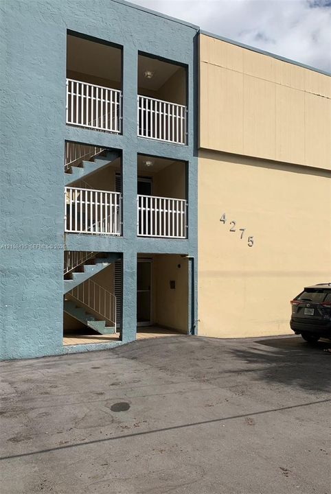 Exterior facade featuring smooth stucco finishes, tiered open-air balconies with metal railings, and integrated staircases