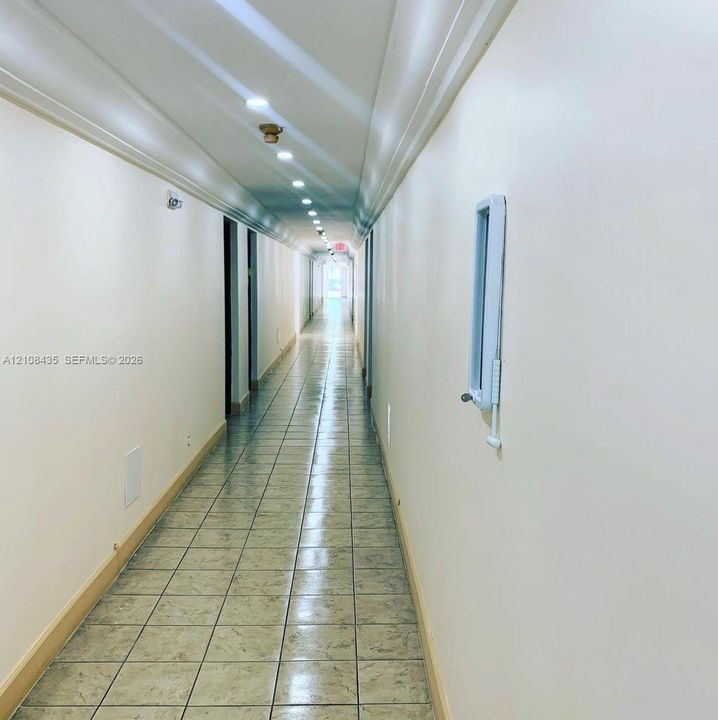 Hallway featuring neutral wall finishes, tile flooring, and recessed ceiling lighting