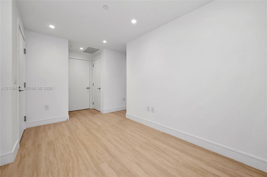 Interior space featuring wood-finish flooring, recessed lighting, and white interior doors