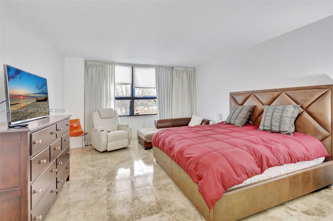 Polished stone flooring, floor-to-ceiling windows, and recessed lighting