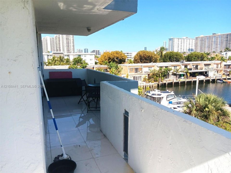Covered balcony featuring white tile flooring and concrete masonry walls overlooking the canal