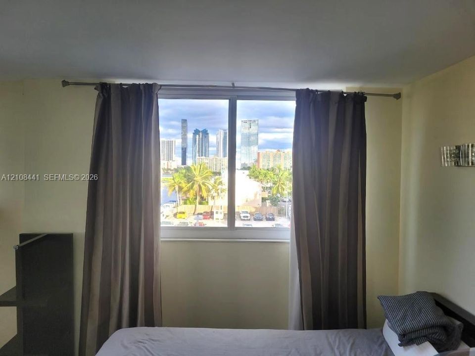 Large window with a skyline backdrop and wall-mounted metal light fixture