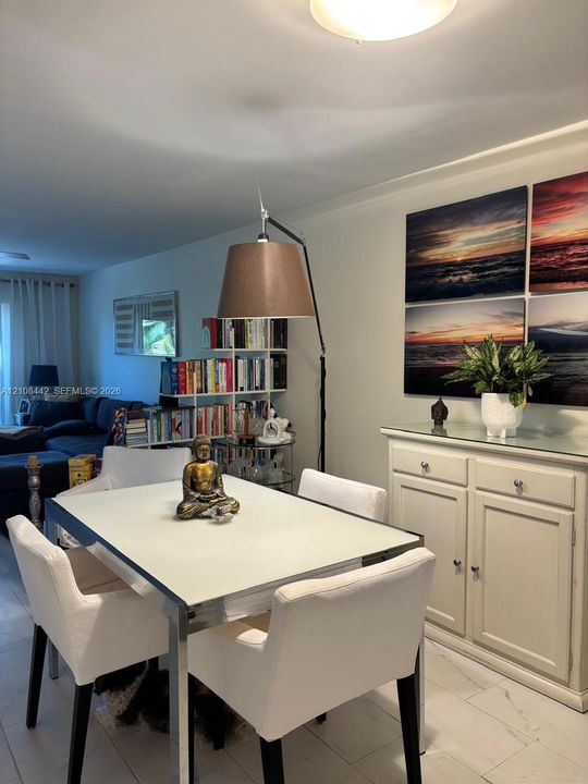 Dining area featuring large-format tile flooring and a built-in cabinetry unit with a glass top