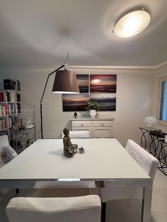 Built-in floor-to-ceiling shelving, light-colored tile flooring, flush-mount elliptical ceiling lighting, and window shutters