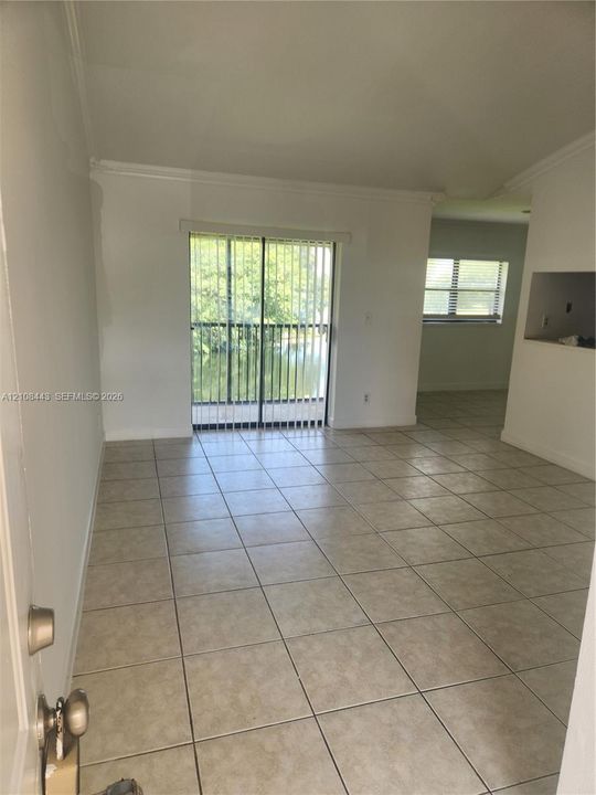 Neutral-toned ceramic tile flooring, floor-to-ceiling sliding glass doors, and a built-in architectural wall cutout