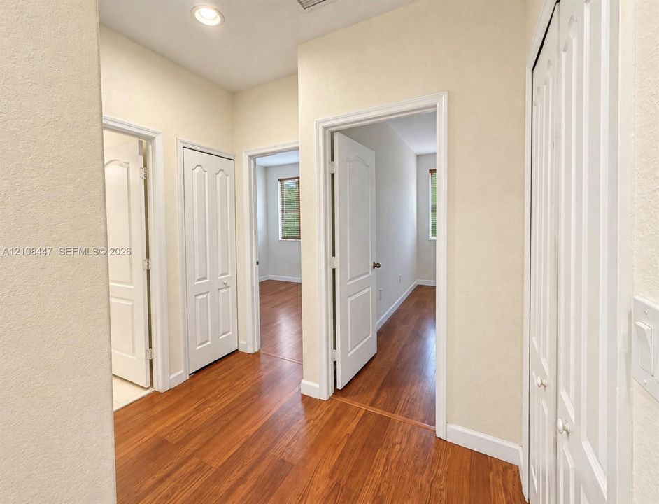 Hallway featuring wood-finish flooring, recessed lighting, and multi-panel interior doors