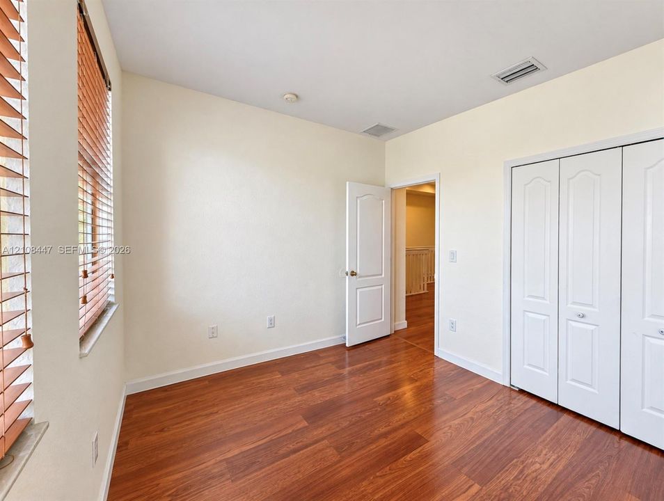 Wood-finish flooring, multi-panel closet doors, and adjustable horizontal window blinds