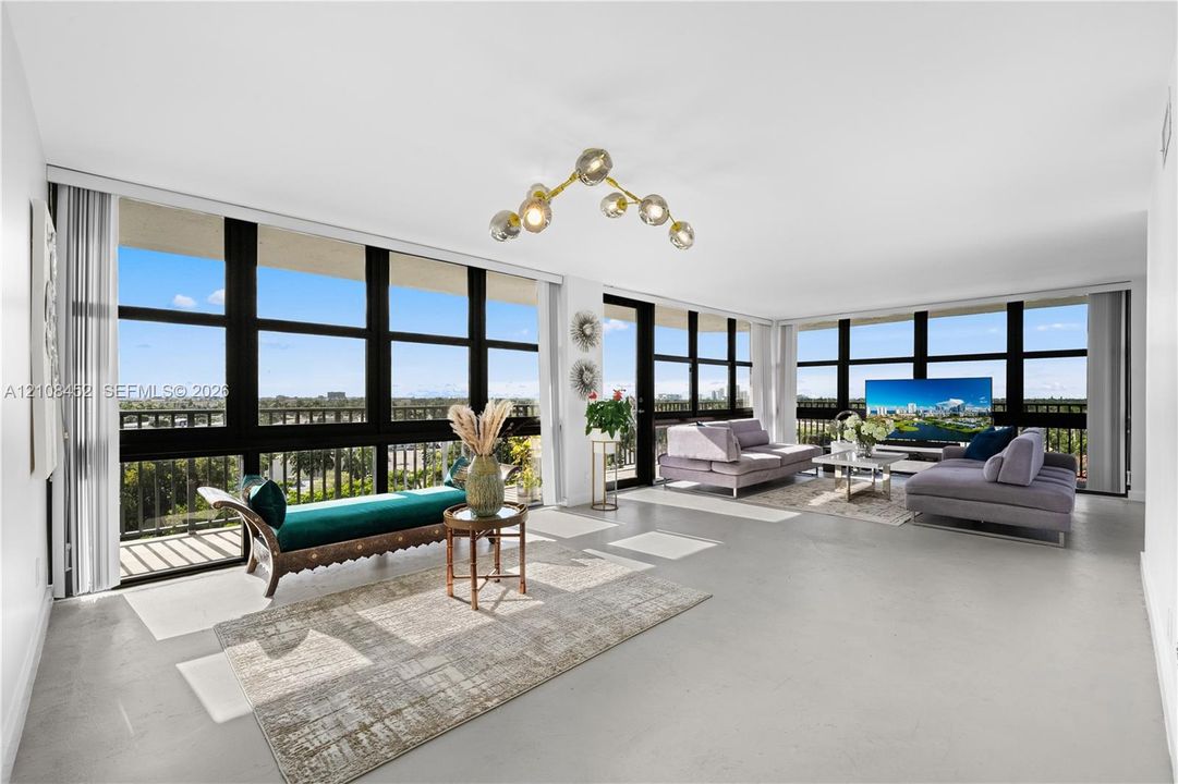 Expansive open-concept room featuring floor-to-ceiling black-framed windows, neutral polished flooring, and a multi-globe architectural chandelier