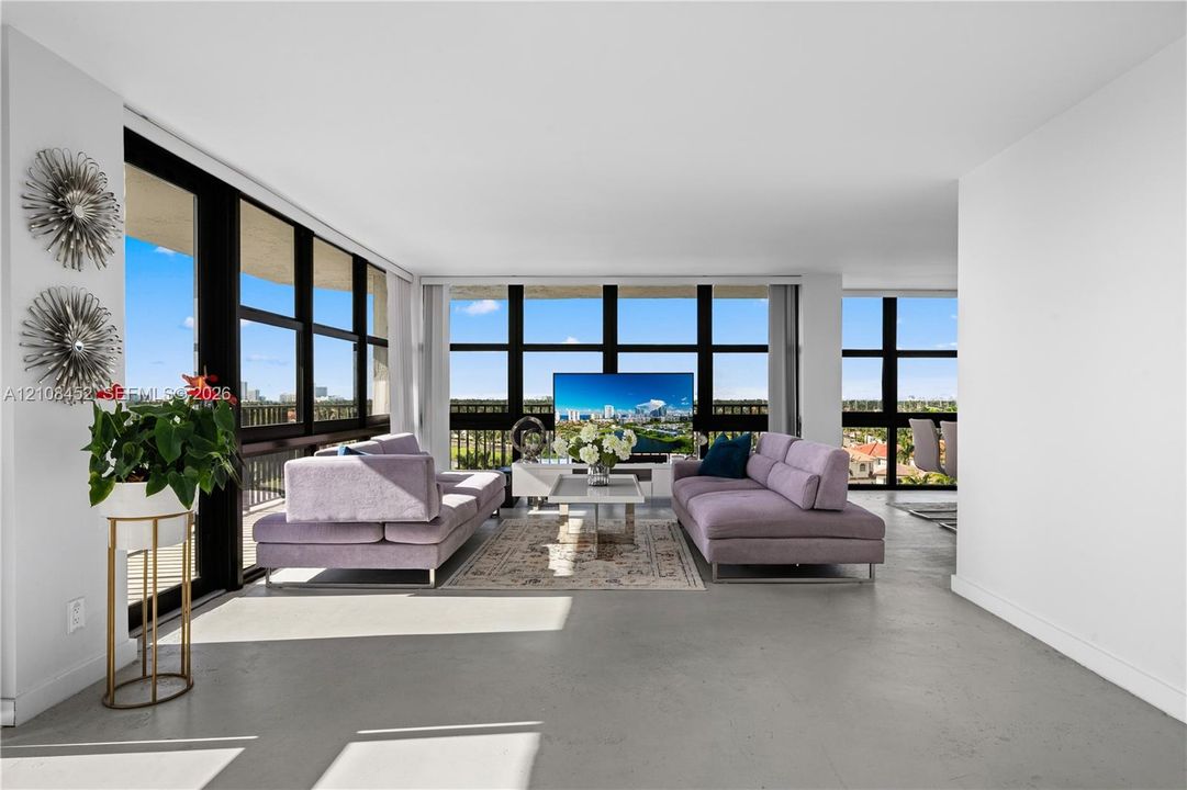 Open-concept interior featuring floor-to-ceiling windows with expansive exterior scenery, polished concrete flooring, and metal-framed balcony access
