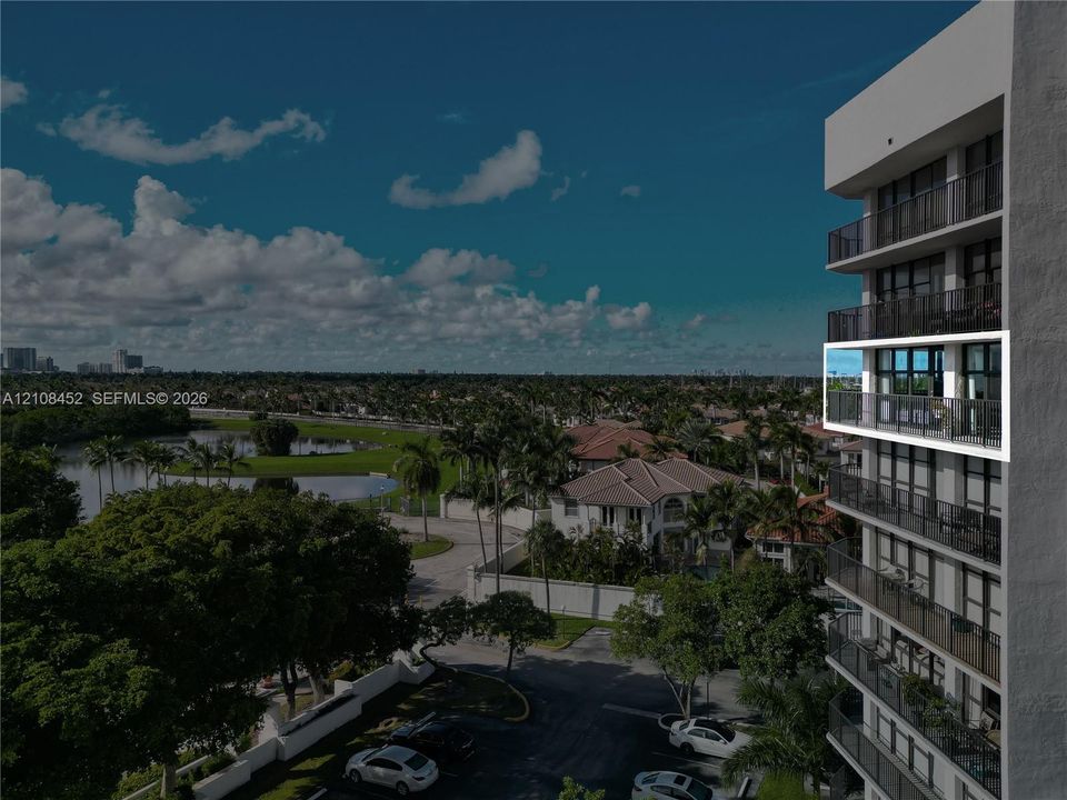High-rise building exterior featuring private balconies with black metal railings and floor-to-ceiling glass doors